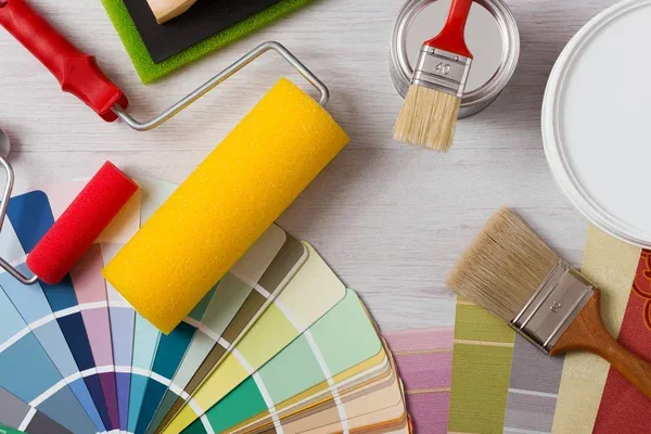 Paint swatches, rollers and brushes laid out for a color consultation